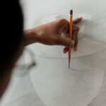 Close up of student hand holding pencil practicing sketching techniques while studying at art school, people developing drawing skills. Artist creating sketch, creating artwork